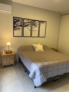 a bedroom with a bed and a table with a lamp at Ocean Apartments in Ciudad Lujan de Cuyo