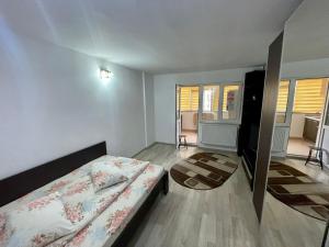 ein kleines Schlafzimmer mit einem Bett und einem TV in der Unterkunft Garsoniera moderna parcare internet in Piteşti