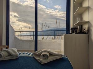 Habitación con ventana grande y toallas en el suelo en Coral, en Frangokastello