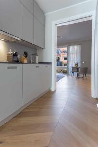 a kitchen with white cabinets and a wooden floor at Luxury Home / 2-Raum-Apartment an der Frauenkirche in Dresden