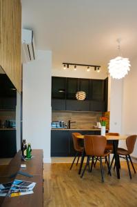a dining room and kitchen with a table and chairs at Słoneczny Apartament in Ustronie Morskie