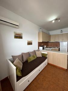 a couch in a living room with a kitchen at Maroulitsas Sea Esta 1 in Haraki