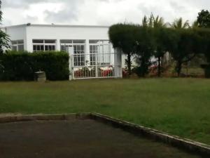a white building with a large window in a yard at Fleury Sur Mer Trou aux Biches in Trou aux Biches