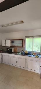 a large kitchen with white cabinets and windows at Fleury Sur Mer Trou aux Biches in Trou aux Biches