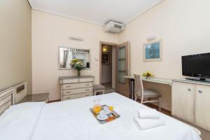 ein Zimmer mit einem Bett und einem Tisch mit Getränken darauf in der Unterkunft Lido Hotel in Kateríni