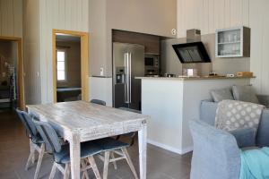 Il dispose d'une cuisine et d'un salon avec une table et des chaises en bois. dans l'établissement Résidence MV Lodge, à La Couarde-sur-Mer