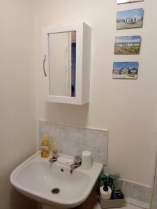 ベクスヒルにあるLovely 1-bedroom flat within minutes from the beach!の白い洗面台と鏡のあるバスルーム +10枚の写真