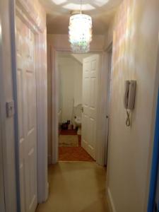 a hallway with a bathroom with a toilet and a chandelier at Lovely 1-bedroom flat within minutes from the beach! in Bexhill