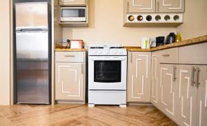 金斯敦的住宿－Royal Bliss Apartment Suites，厨房配有白色炉灶和冰箱。