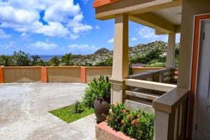 a house with a balcony with a view of the ocean at Royal Bliss Apartment Suites in Kingstown