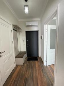 an empty hallway with a black door and wooden floors at Stylish apartment in City Center in Chişinău