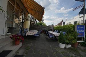patio ze stołami i krzesłami przed restauracją w obiekcie Pension Döppert w Norymberdze