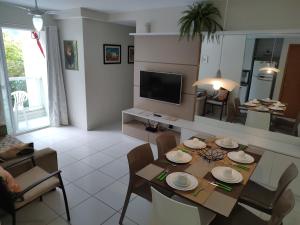 ein Wohnzimmer mit Tisch und Stühlen und einem Fernseher in der Unterkunft Flat térreo Palm Village Acqua Porto de Galinhas in Porto De Galinhas + 55 Fotos