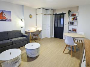 - un salon avec un canapé, des tables et des chaises dans l'établissement Studio Linois, à Brest