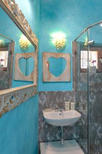 a blue bathroom with a sink and a mirror at Lotus apartment in Szentendre