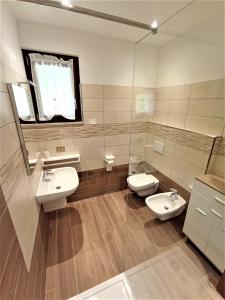 y baño con 2 lavabos, aseo y espejo. en Appartamento Girasole en Ledro