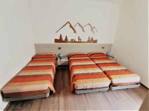 1 Schlafzimmer mit 2 Betten und einer Wand in der Unterkunft Appartamento Girasole in Ledro