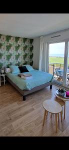 een slaapkamer met een bed, een tafel en een raam bij L'Albâtre in Dieppe