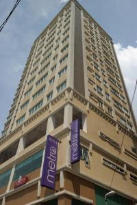 Un grand bâtiment avec des panneaux violets devant lui dans l'établissement Metro Hotel Bukit Bintang, à Kuala Lumpur