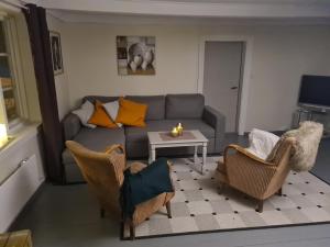 a living room with a couch and chairs and a table at Lite hus ved sjøen 