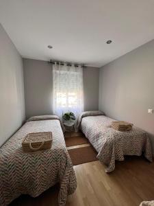 a bedroom with two beds and a window at Apartamento A Tixola ,Casco Histórico in Pontevedra