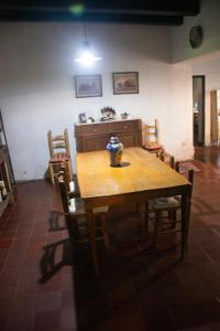 a wooden table with chairs and a vase on it at La Finca de Buen Orden in San Martín