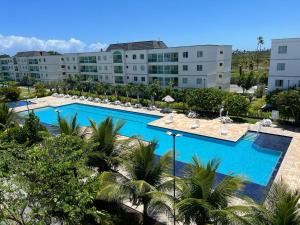 einen Blick über einen großen Pool mit Palmen in der Unterkunft Flat térreo Palm Village Acqua Porto de Galinhas in Porto De Galinhas