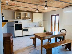 cocina con mesa de madera y comedor en Casa Vistabella, en Frassinello Olivola