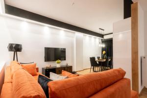 a living room with an orange couch and a table at Acropolis Exclusive Apartment in Athens