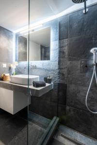 a bathroom with a sink and a glass shower at Acropolis Exclusive Apartment in Athens