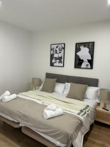 1 dormitorio con 1 cama grande y toallas. en Guggenheim, en Bilbao