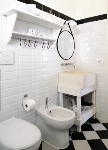 Baño blanco con aseo y lavamanos en Saja Country House, en Acireale