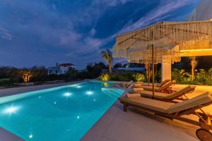 AsgourouにあるGatsby Rhodes-Brand New Seaview Villaのラウンジチェアとパラソル付きのスイミングプールを併設しています。