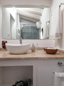 a bathroom with a sink and a large mirror at Il nido dei Priori in Volterra