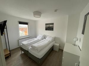 una camera da letto con due letti con lenzuola bianche di City-Apartments Hannover ad Hannover