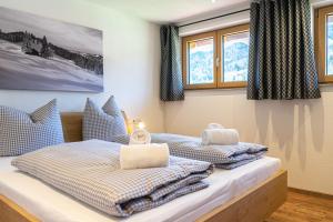two beds in a room with windows and towels at Thaler Höhe in Oberstaufen