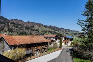 une route menant à une maison avec une montagne dans l'établissement Himmeleck, à Oberstaufen