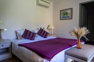 a bedroom with a large bed with a purple blanket at Logis du Champ De Mars in Puy-Saint-Martin