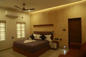 1 dormitorio con 1 cama y ventilador de techo en Casa Orchid, en Alleppey