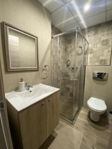 a bathroom with a sink and a shower and a toilet at Aquae Stays in St Paul's Bay