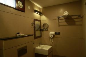 a bathroom with a sink and a mirror at Casa Orchid in Alleppey