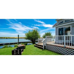 a house with a deck and a view of the water at Snug Harbor RV Park & Marina in Walnut Grove