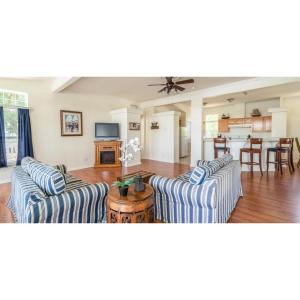 a living room with two couches and a kitchen at Snug Harbor RV Park & Marina in Walnut Grove