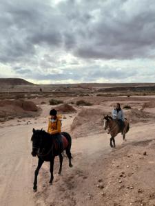 two people riding horses on a dirt road at Guest housse Kasbah tifaoute in Aït Benhaddou