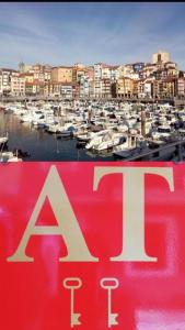 a sign in front of a marina with boats at Andra Mari Apartamentu Turistikoak in Bermeo