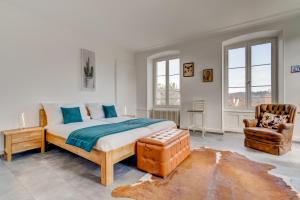 een slaapkamer met een bed en een stoel bij The 5 Continents I & II - 320 m2 by Stay Swiss in Porrentruy