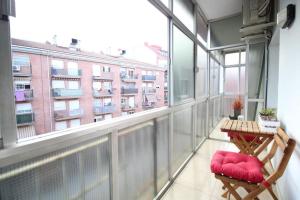 balcón con mesa y sillas y ventana grande en Nice new apartment only 30min to Barcelona center., en Granollers
