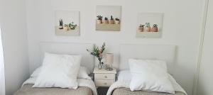a bedroom with two beds with pillows and cactuses at Conde de la Encina in Trujillo