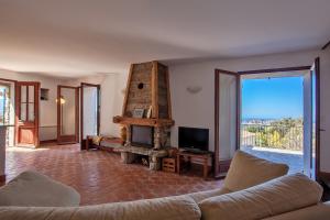 ein Wohnzimmer mit einem Sofa und einem Kamin in der Unterkunft Casa Poggio in Barbaggio
