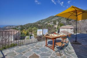 einen Tisch und Stühle mit Sonnenschirm auf einer Terrasse in der Unterkunft Casa Poggio in Barbaggio